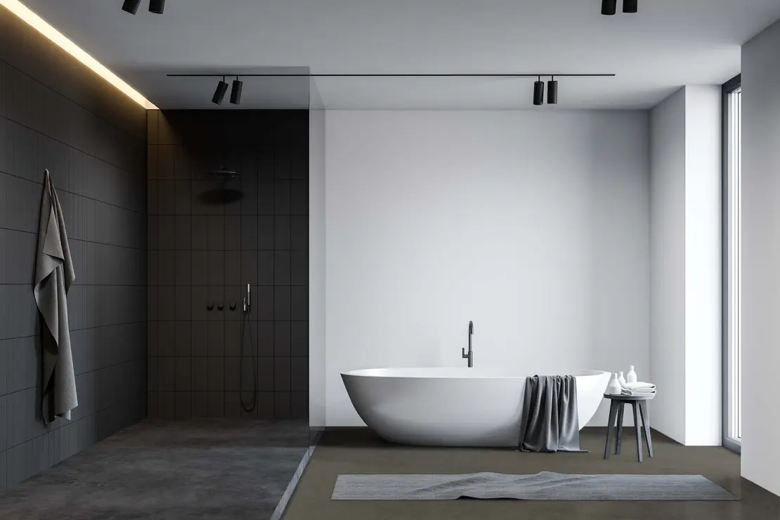 Bañera con pavimento de microcemento de tonalidad gris profundo.